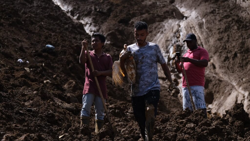 Habitantes de la vereda Granizal, remueven tierra y basura después del deslave, este miércoles.