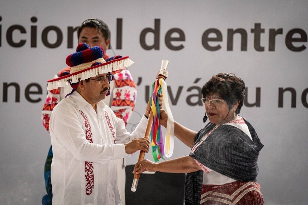 Hugo Aguilar recibe un bastón de mando de una representante de las comunidades indígenas en Ciudad de México.