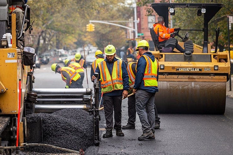 Trabajadores repavimentando una calle urbana.