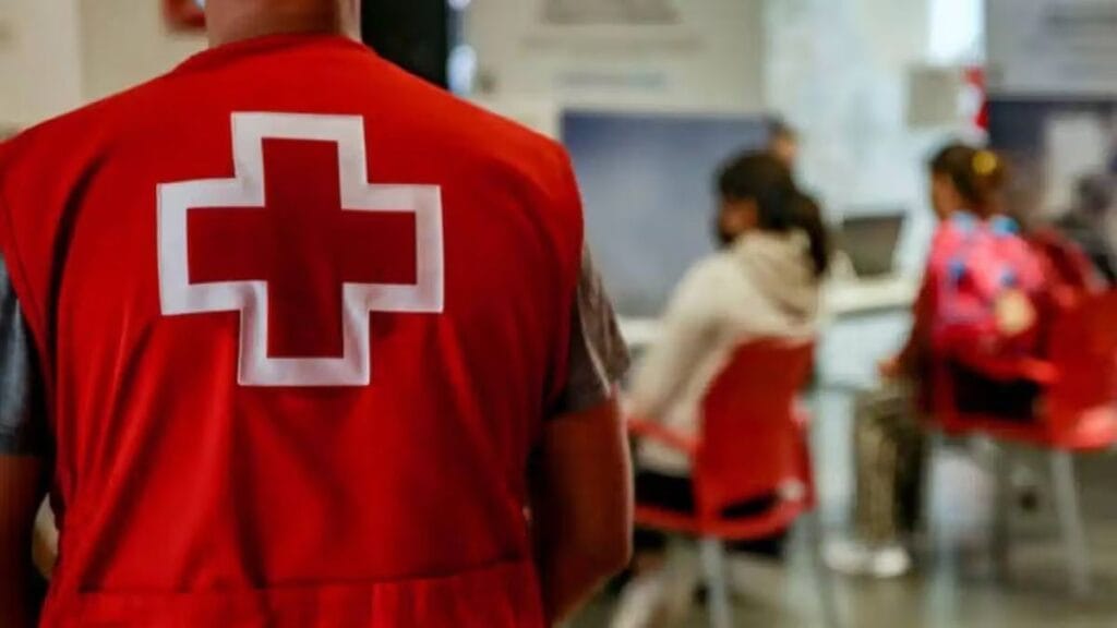 Un trabajador de Cruz Roja de espaldas en una oficina