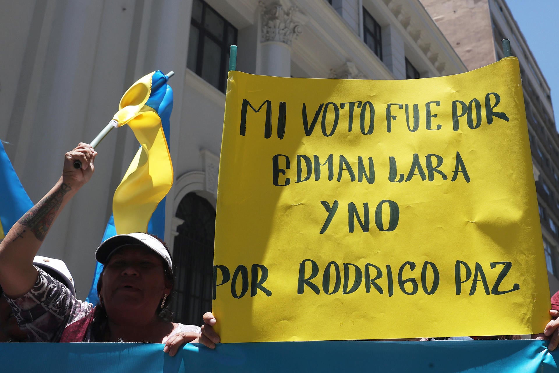 Personas sostienen carteles y banderas en apoyo al vicepresidente de Bolivia, Edmand Lara, durante una protesta afuera de la vicepresidencia este viernes, en La Paz (EFE/ Luis Gandarillas)
