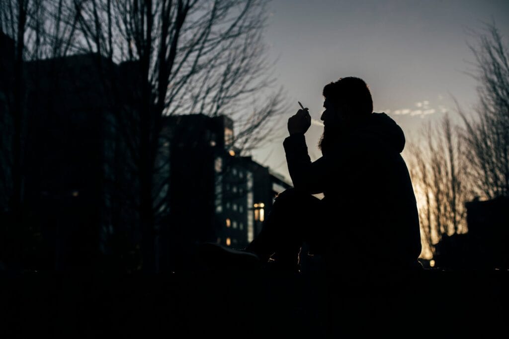 Una persona fuma un cigarrillo en un parque de Santiago de Compostela, en una imagen de archivo.