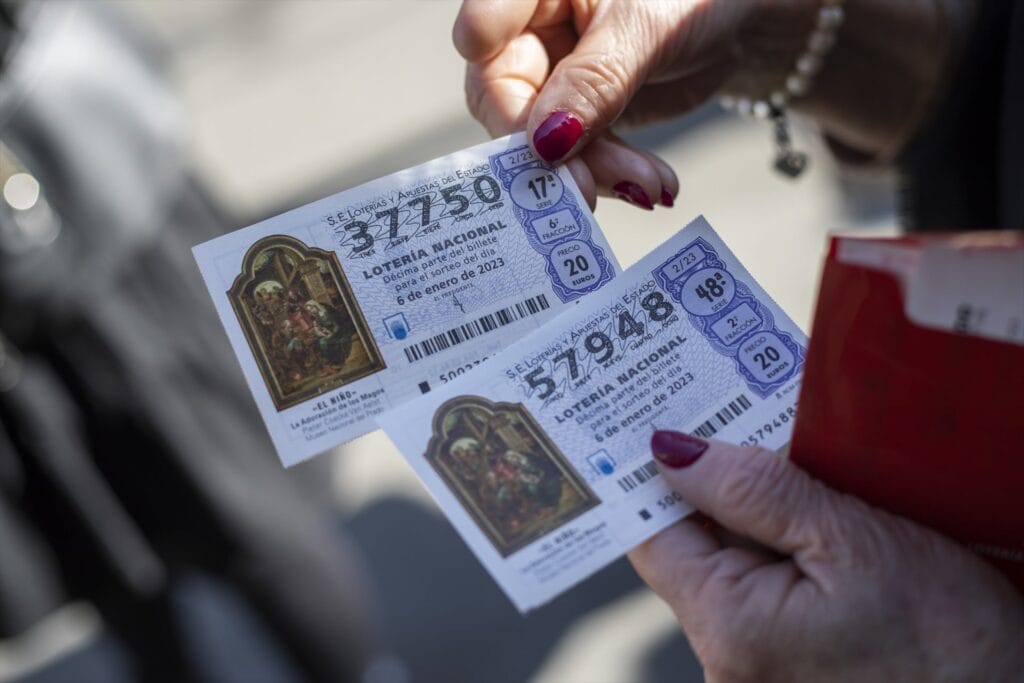 Una persona con dos décimos de la Lotería del Niño. (María José López / Europa Press)