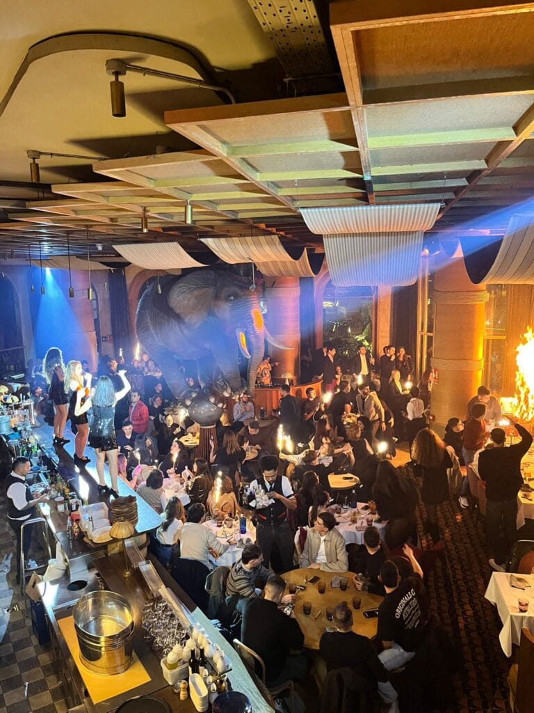 Imagen cedida por una asistente al restaurante Fanático, en Madrid, en la que se ve a tres gogós bailando sobre la barra mientras el público agita las bengalas, en el instante en que se origina el incendio.