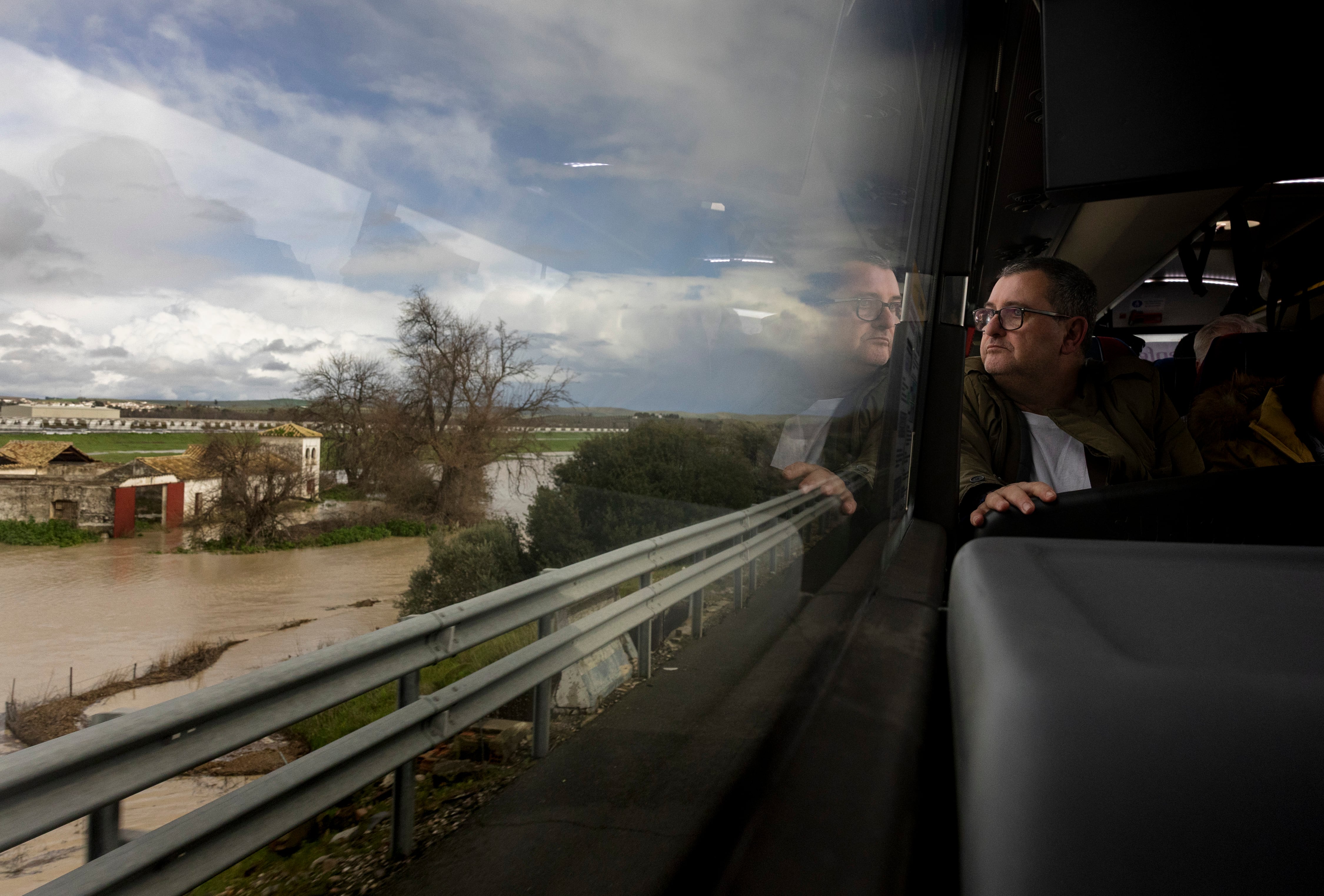 Un pasajero observa una zona inundada desde el bus que le recogió en la estación de Villanueva de Córdoba.