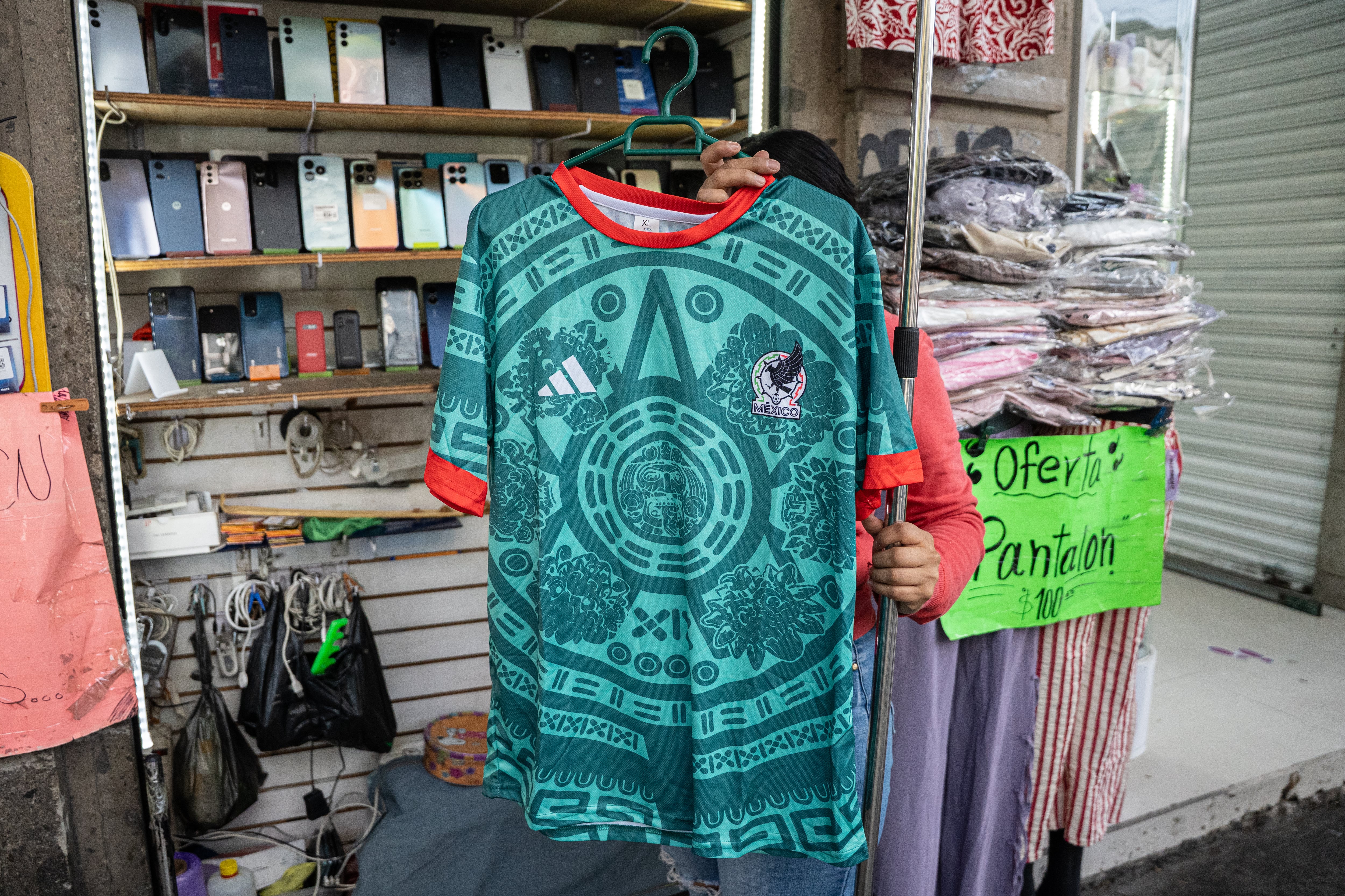Una vendedora muestra una playera de la selección mexicana, en Ciudad de México.