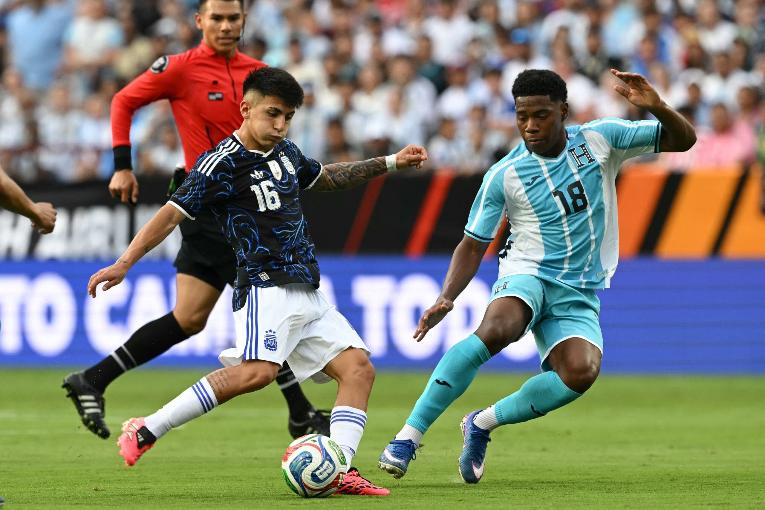 Thiago Almada lanza un pase ante la marca de Dereck Moncada (Créditos: RONALDO SCHEMIDT / AFP)