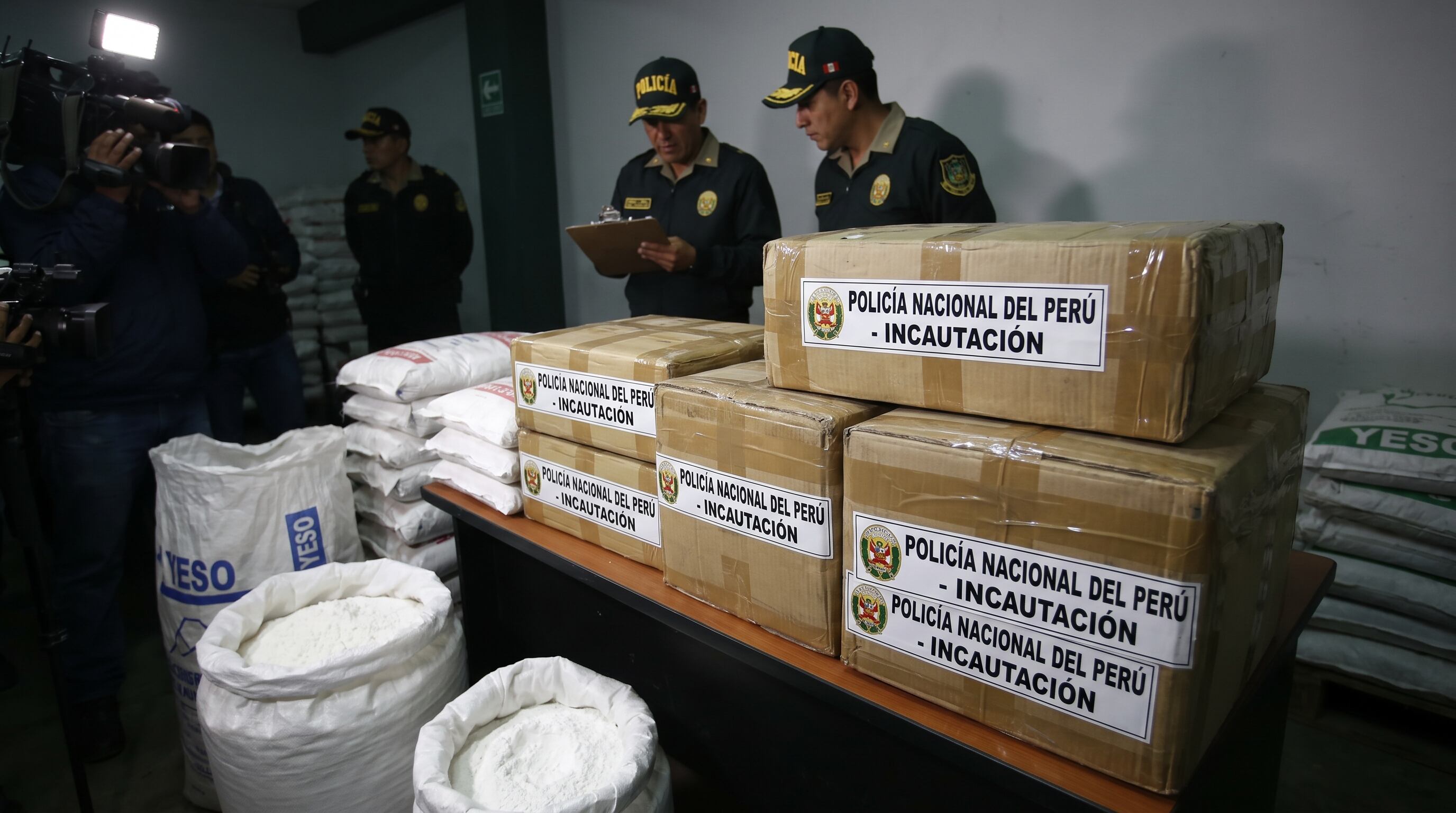 La Policía Nacional del Perú presenta una incautación de cocaína que será sustituida por yeso, mientras un equipo de prensa filma el procedimiento. (Imagen Ilustrativa Infobae)