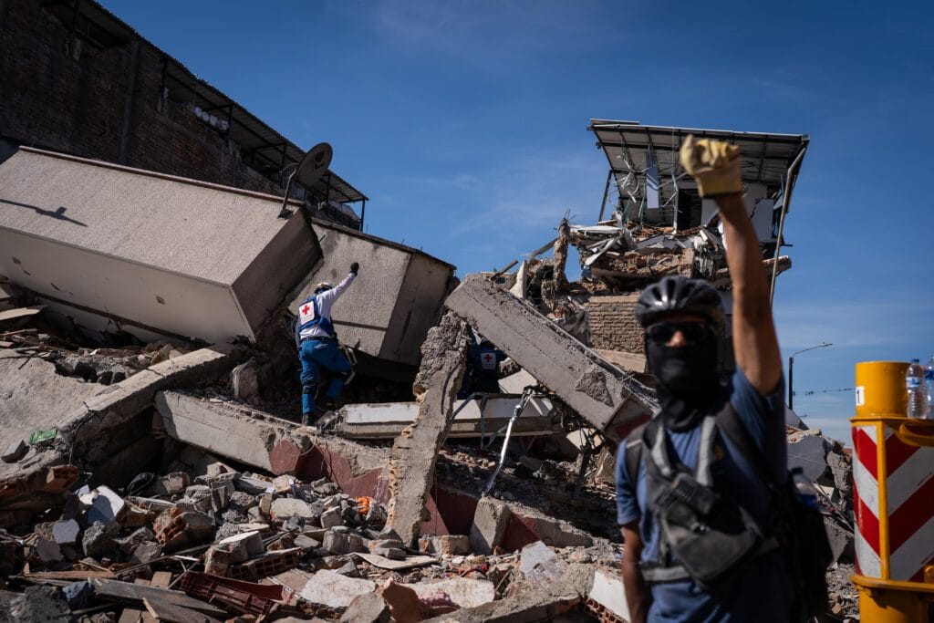 Rescatistas piden silencio en busca de sobrevivientes en un edificio colapsado, en el centro de Pereira, este martes.