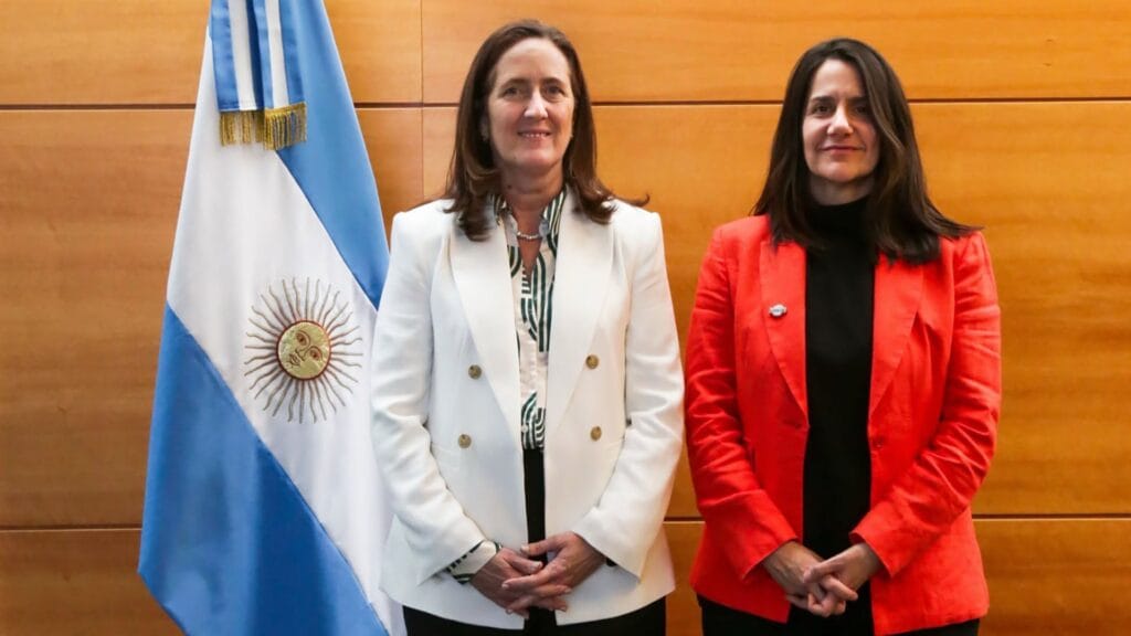 Josefina Pérès posa junto a la bandera argentina tras su designación como nueva directora ejecutiva y técnica de la Comisión Nacional de Actividades Espaciales.