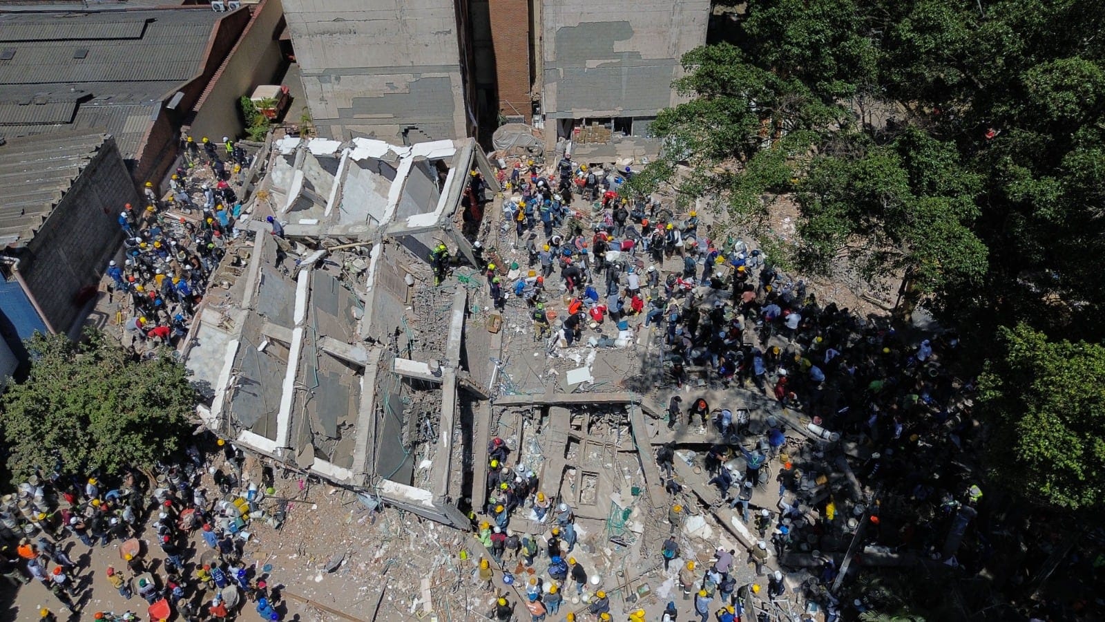 Cientos de ciudadanos y equipo de rescate colaboran en la búsqueda de sobrevivientes, en Cali, Colombia, el 11 de agosto.