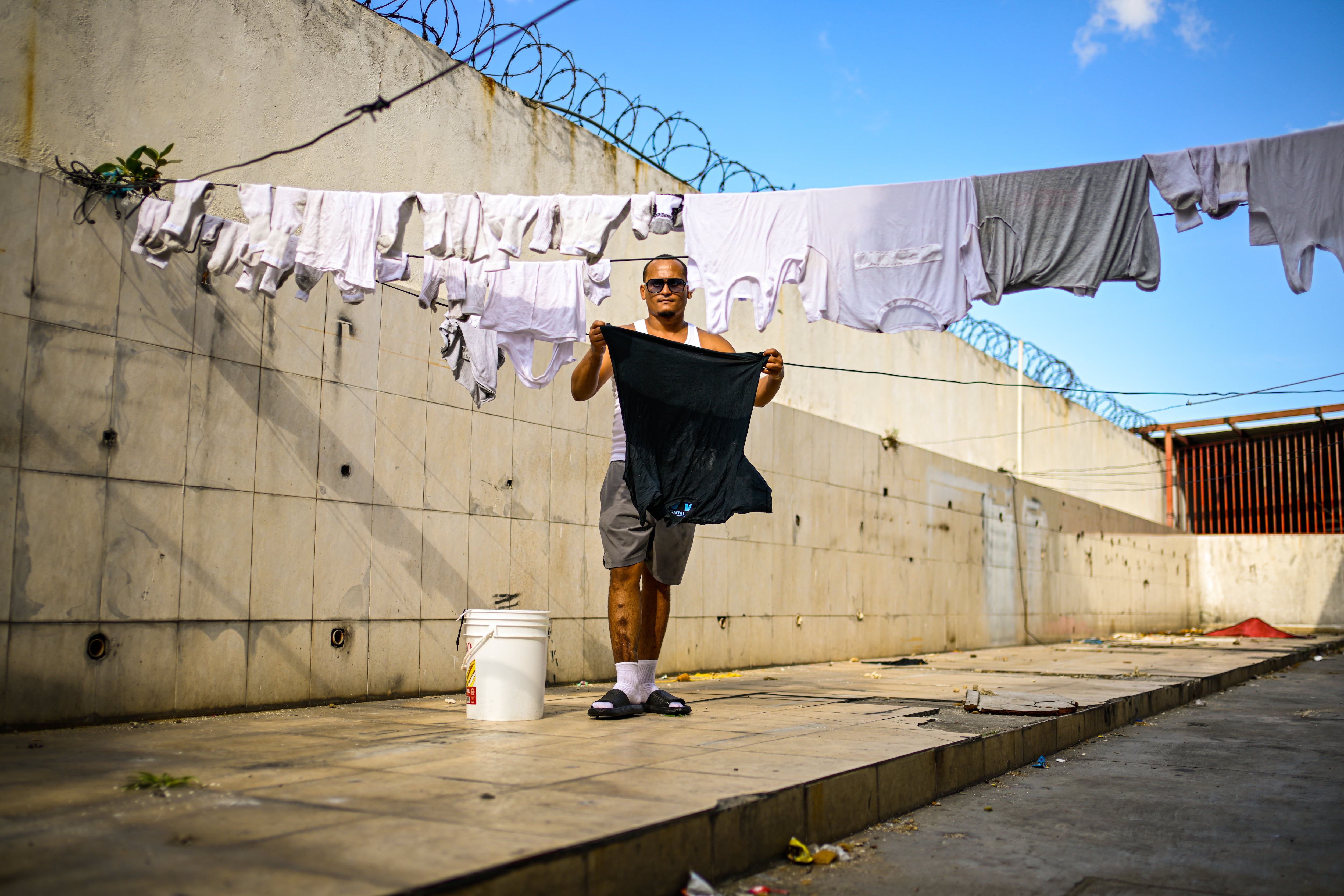 Yeiker García, tiende su ropa para secarla en el patio del refugio La Posada de Catia.