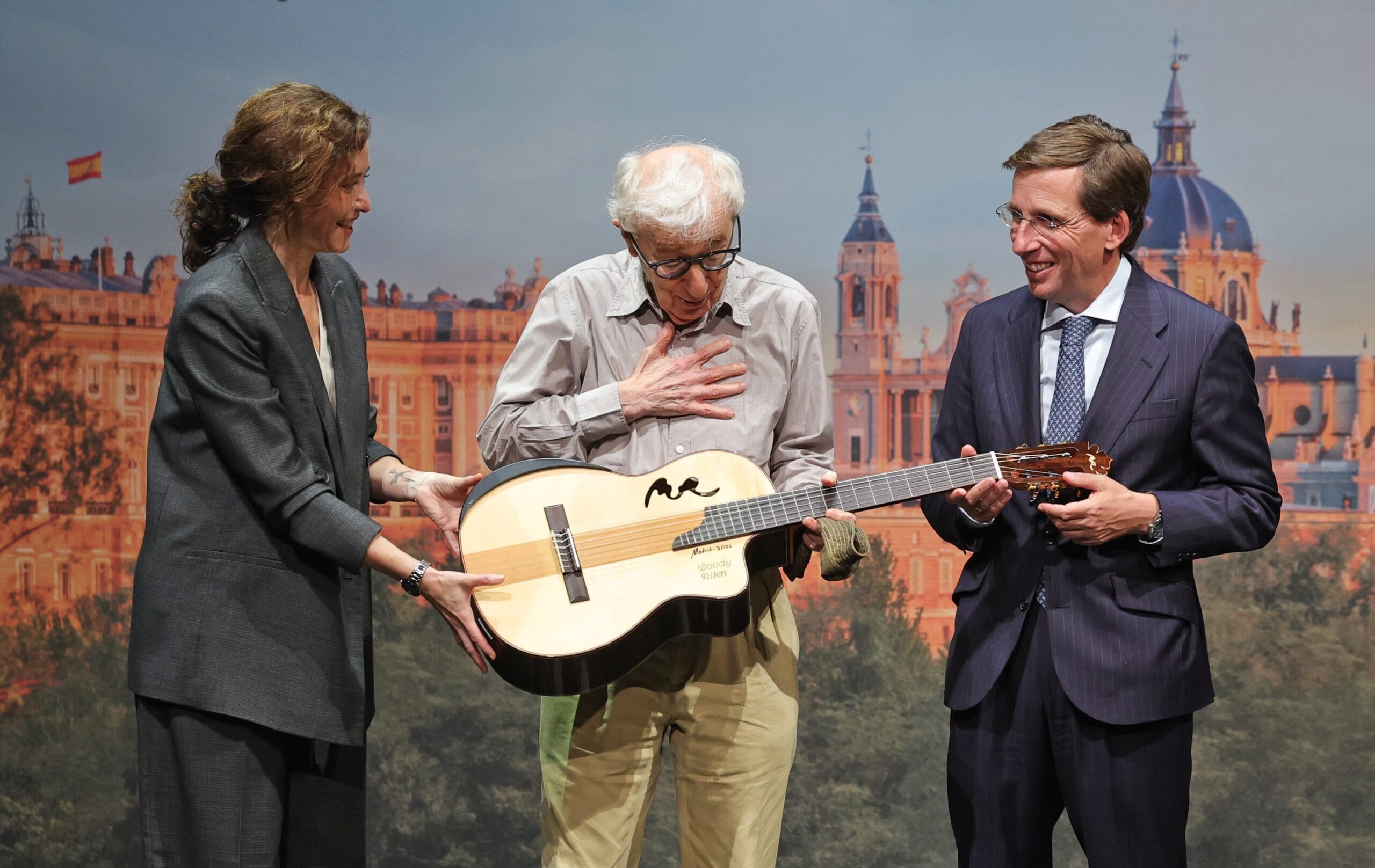 La presidenta de la Comunidad de Madrid, Isabel Díaz Ayuso, y el alcalde de la capital, José Luis Martínez-Almeida, regalan una guitarra al cineasta.